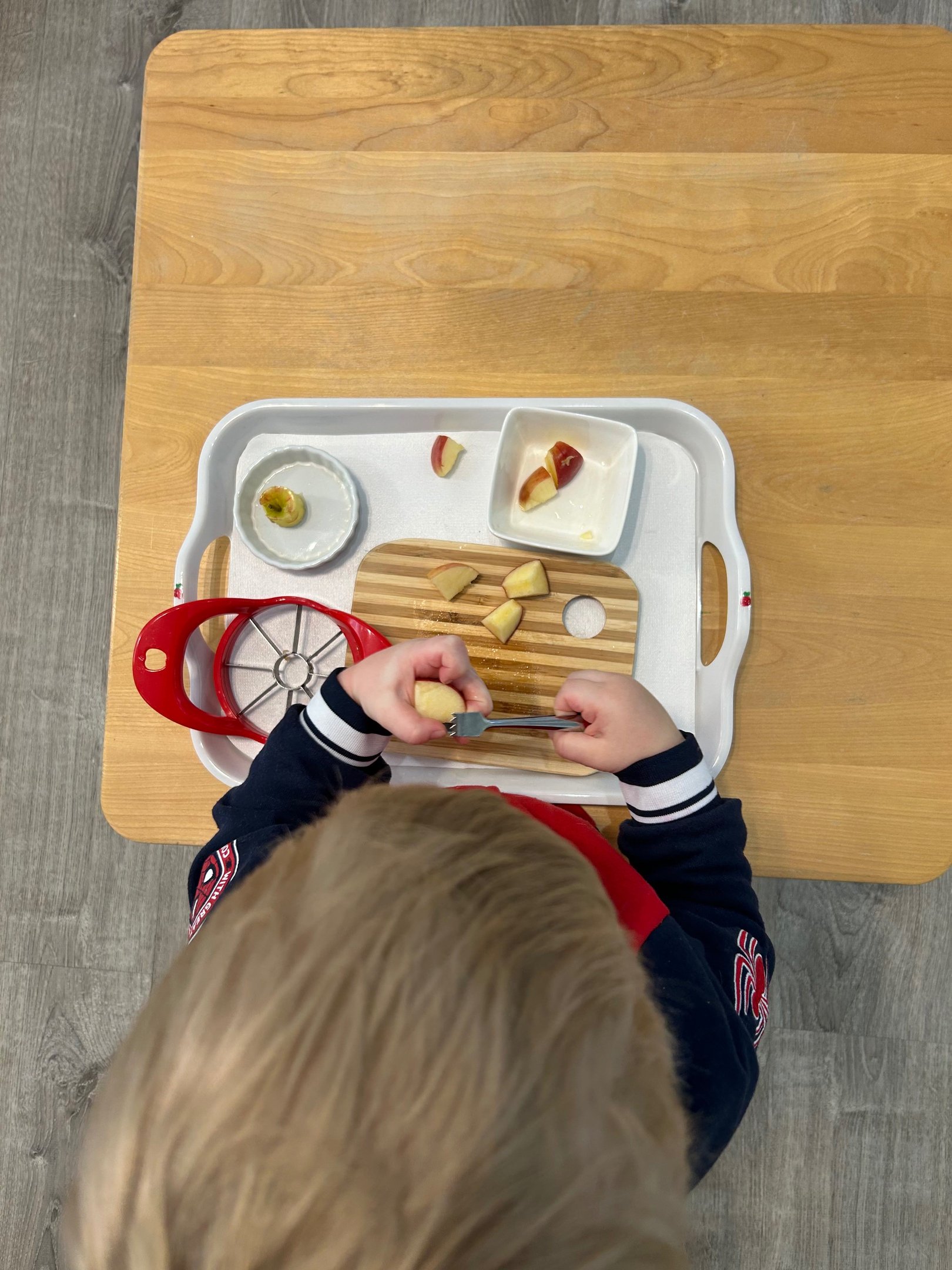 Child preparing fruit at a Montessori practical life table