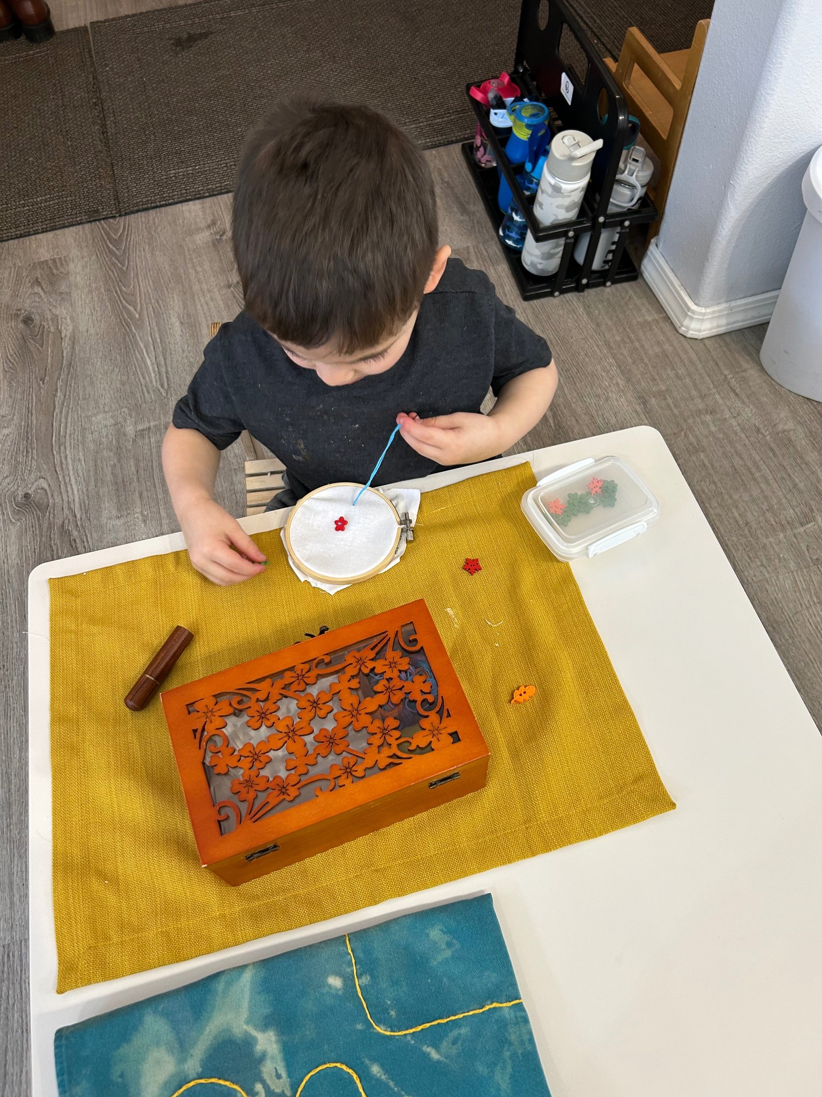 Child practicing embroidery at a Montessori table